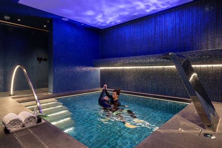 Hydrotherapy pool session at TRIA at MGM MACAU, featuring a therapist-guided water wellness treatment in an intimate spa setting.