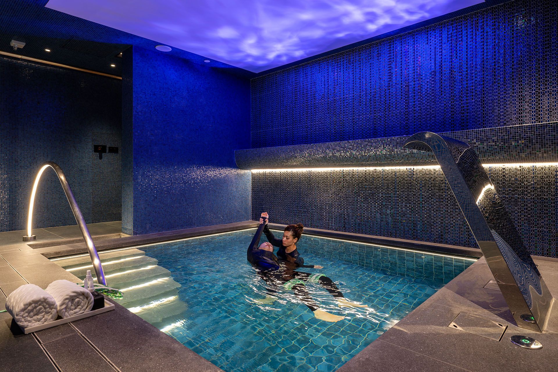 Hydrotherapy pool session at TRIA at MGM MACAU, featuring a therapist-guided water wellness treatment in an intimate spa setting.