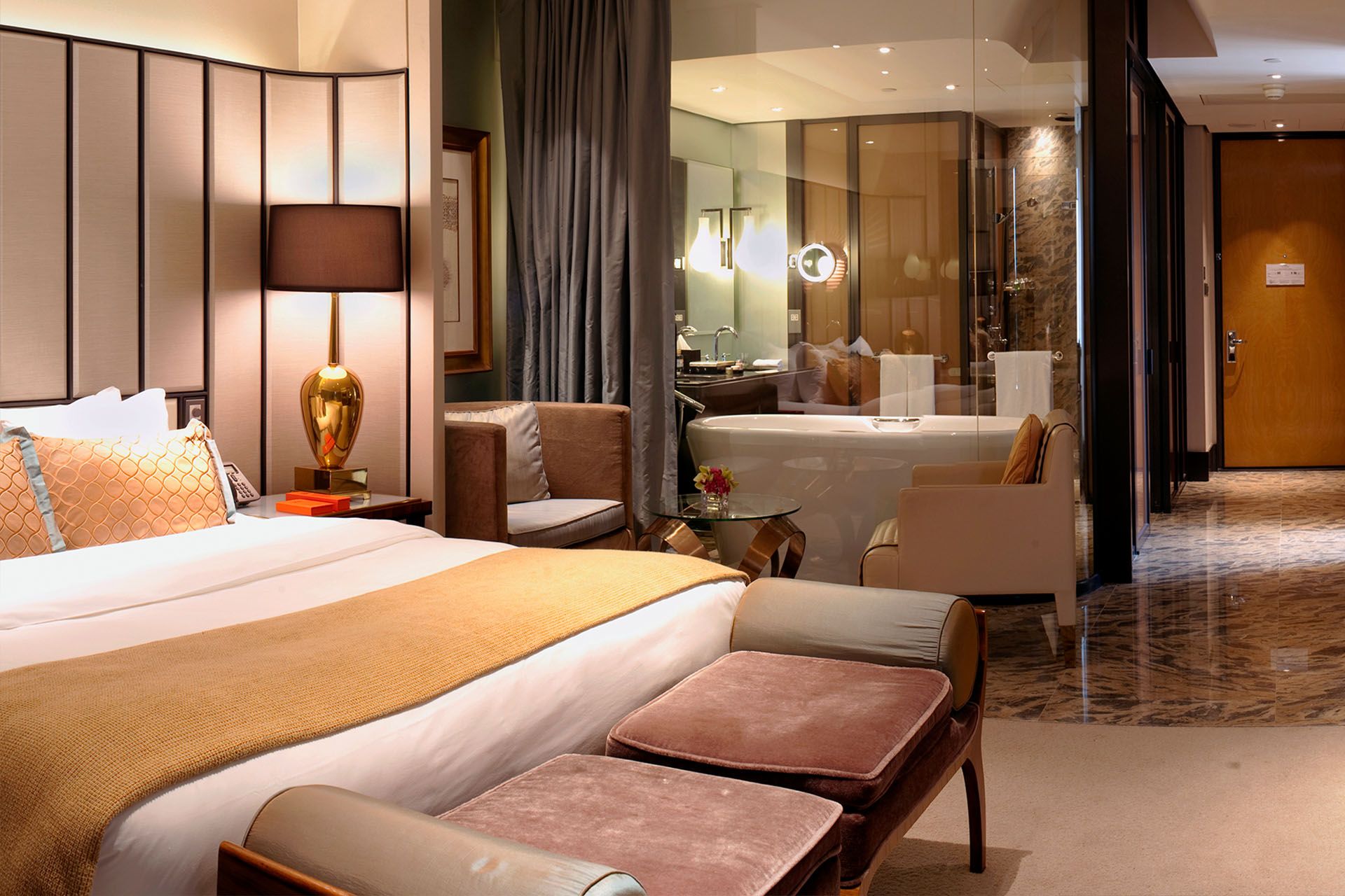 Luxury suite at MGM MACAU featuring a spacious bedroom, elegant furnishings and a freestanding bathtub for a restorative stay.