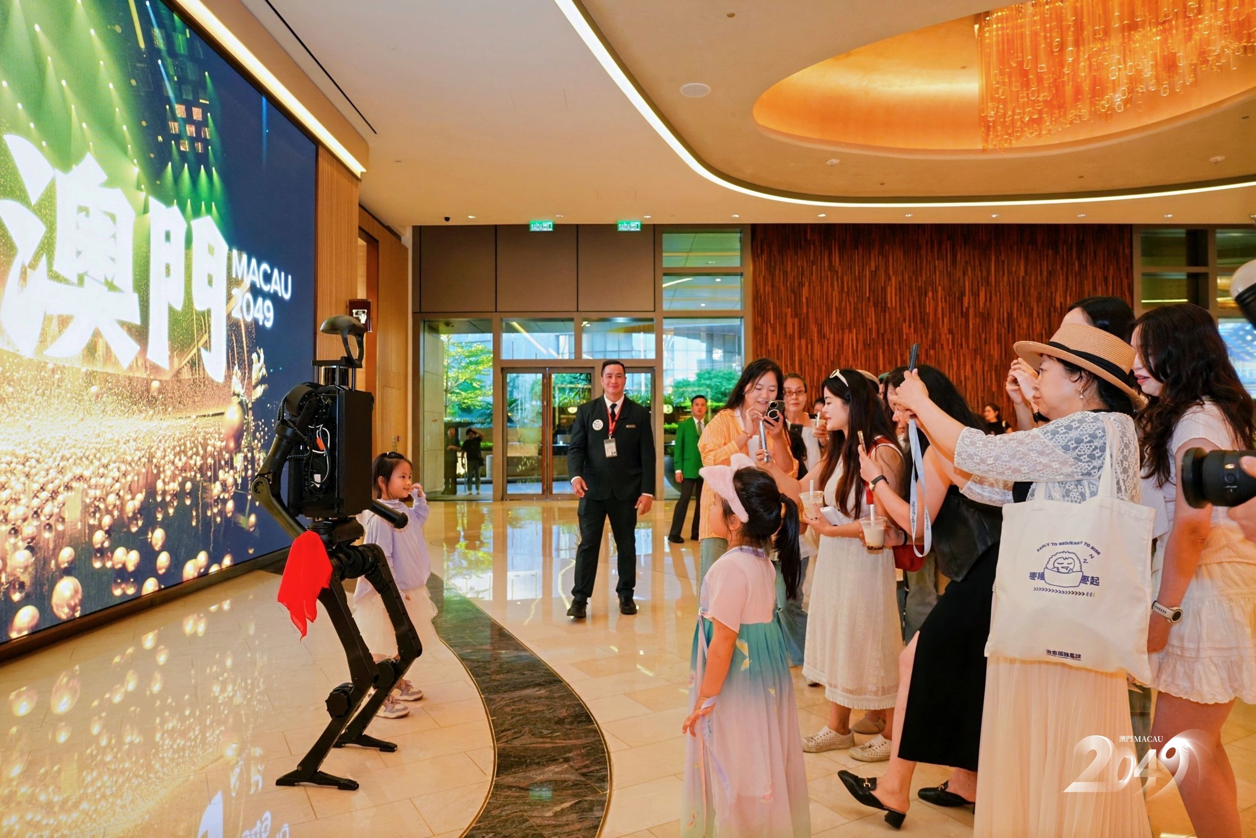 Families and children interact with the robot at “MACAU 2049”, a family-friendly Macau attraction that combines robotics, culture, and immersive entertainment.