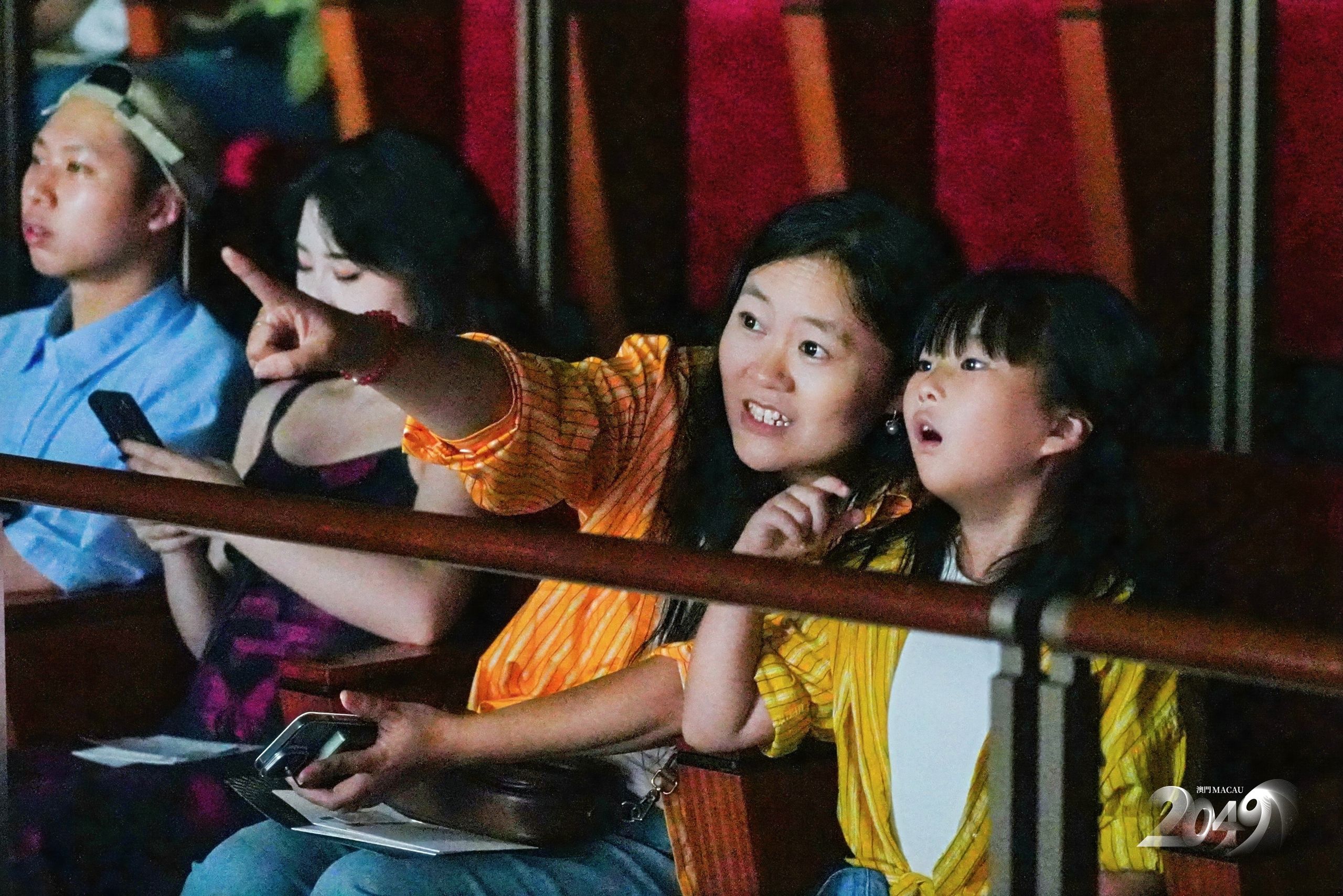 Family audience members watch “MACAU 2049” from the theatre, enjoying an immersive performance that combines technology, culture, and visual storytelling.