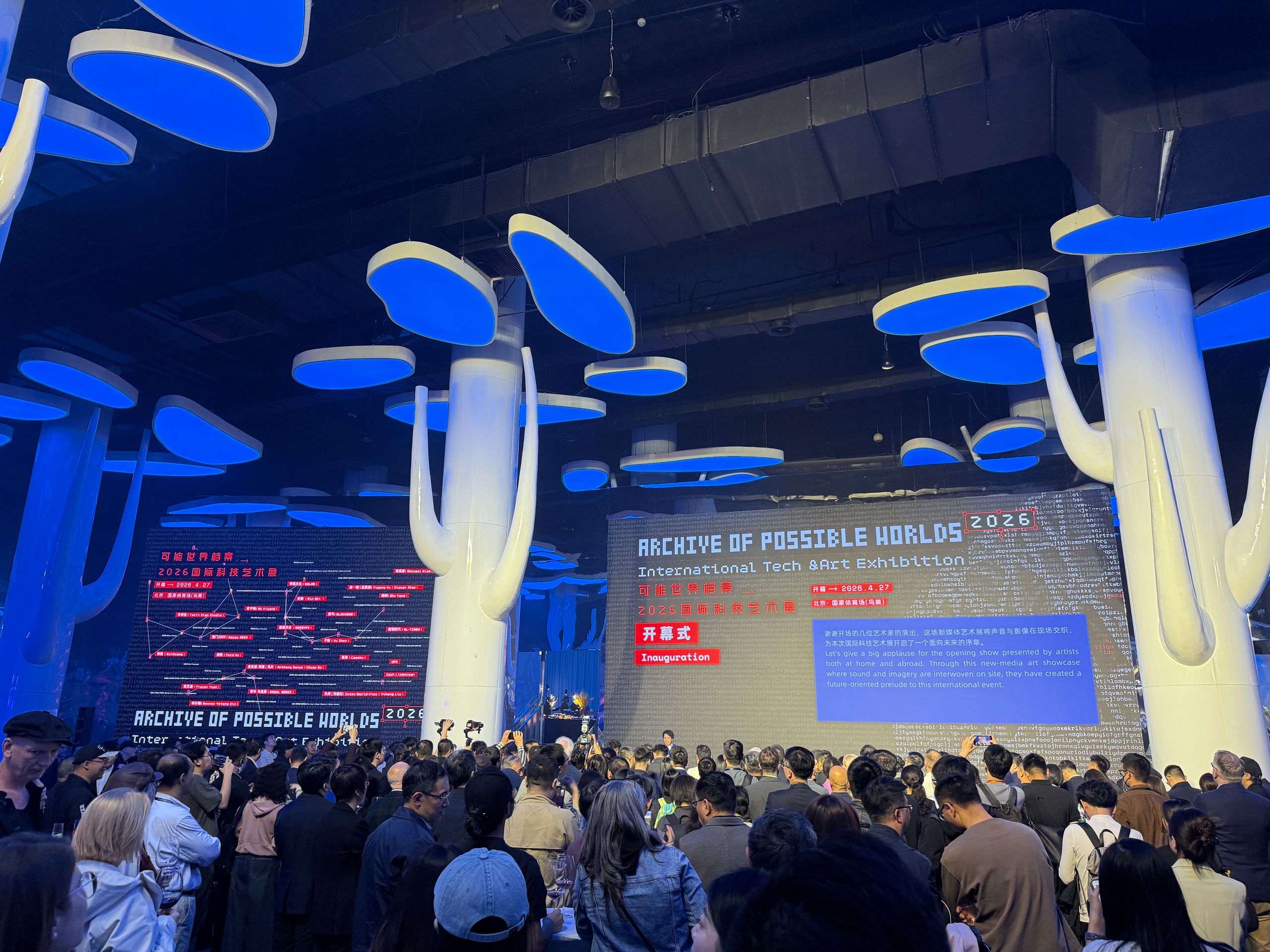Interior view of the Archive of Possible Worlds exhibition, showing audiences, digital installations, and Macau 2049 exhibition panels.