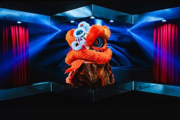 Lion dance head installation displayed against an immersive digital backdrop, combining traditional cultural imagery with contemporary tech‑art visuals.