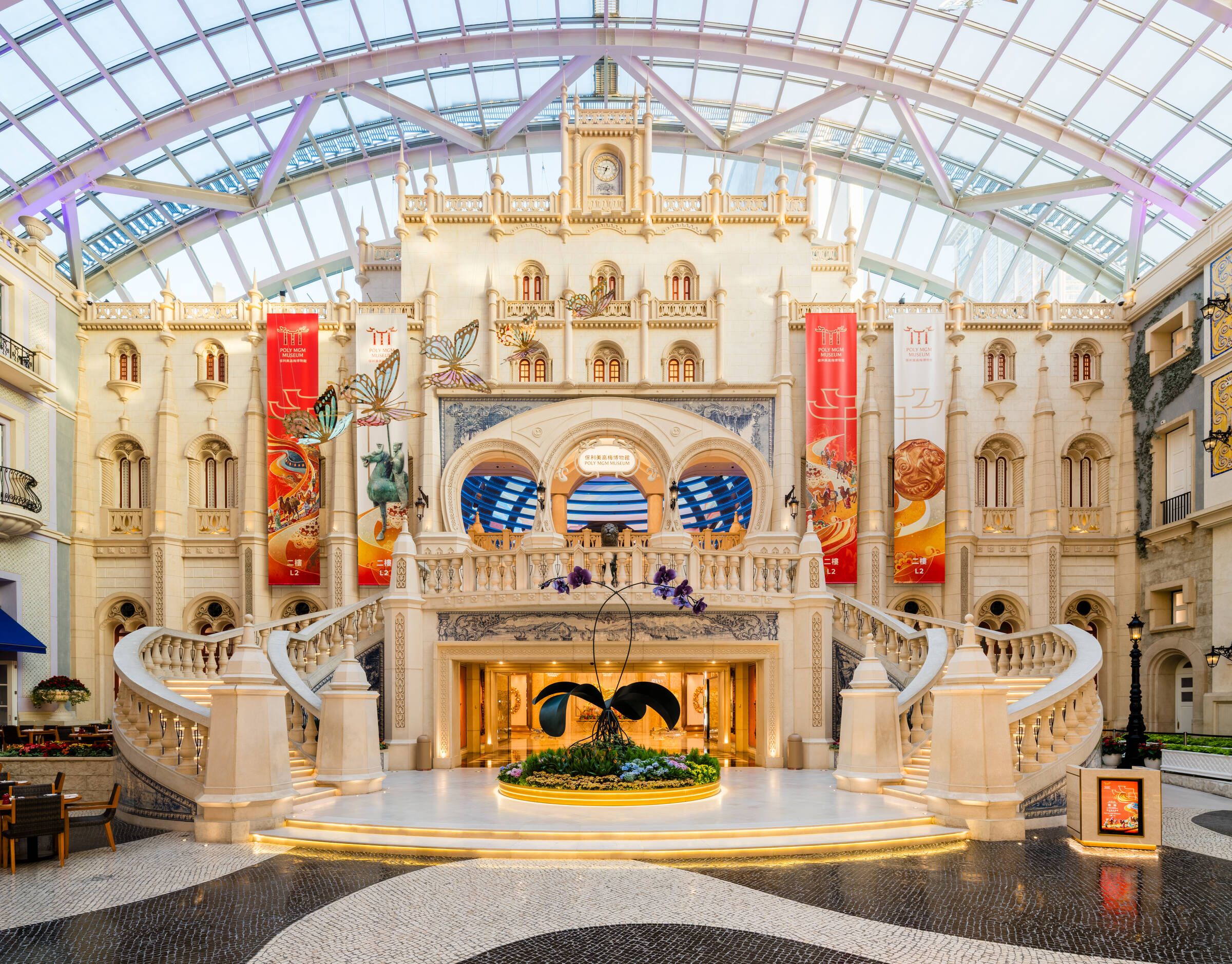 Grande Praça at MGM MACAU, inspired by a grand Portuguese railway station, features a dramatic European-style façade, sweeping staircases and a glass canopy filled with natural light.